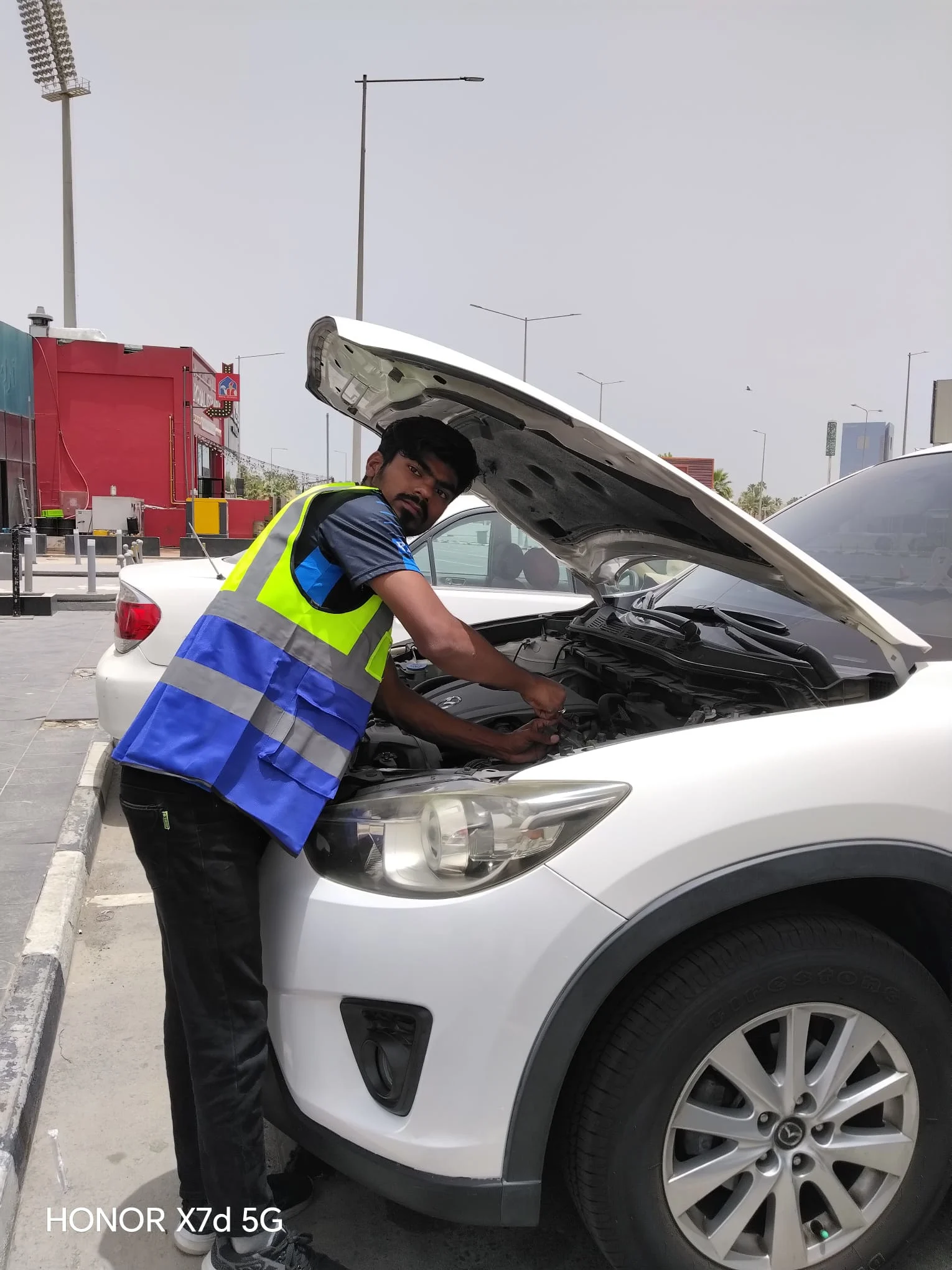 Technician replacing a car battery roadside in Qatar